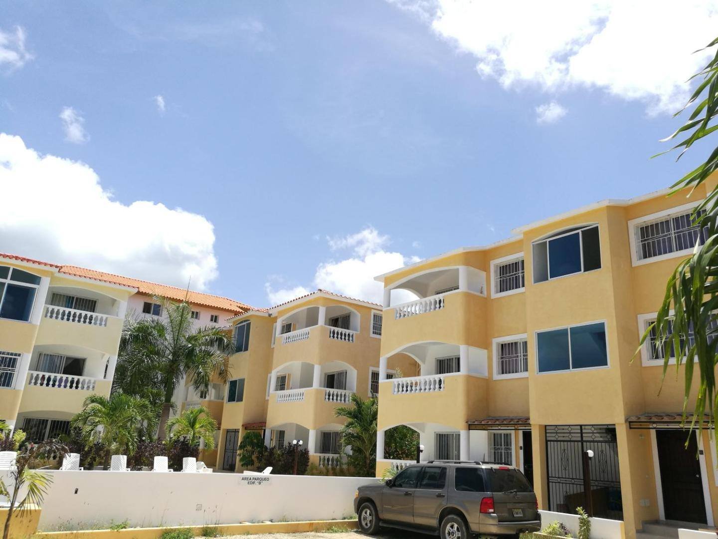 Apartment buildings with white balustrades seen from the stone-paved path