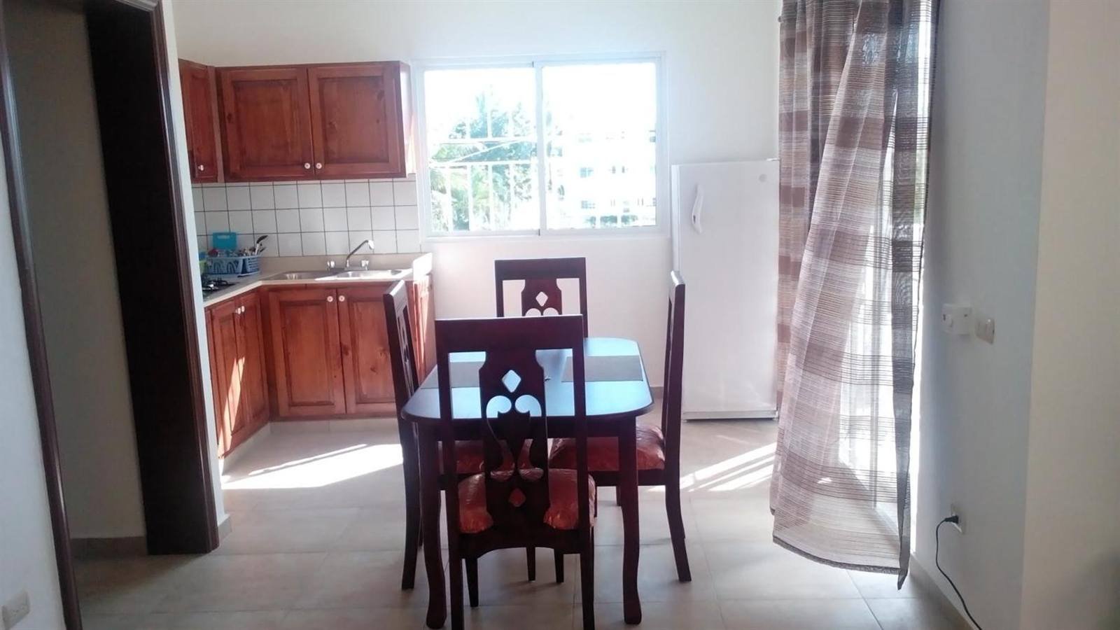Kitchen and dining area with a wooden table and a window